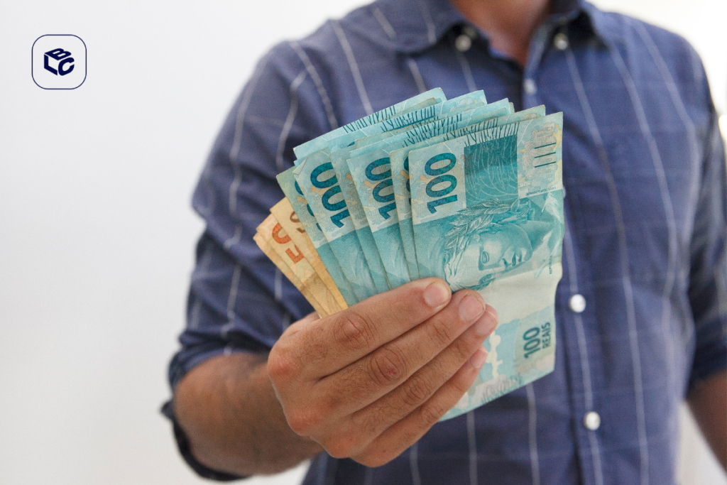 Mão segurando notas de 100 reais em português do Brasil