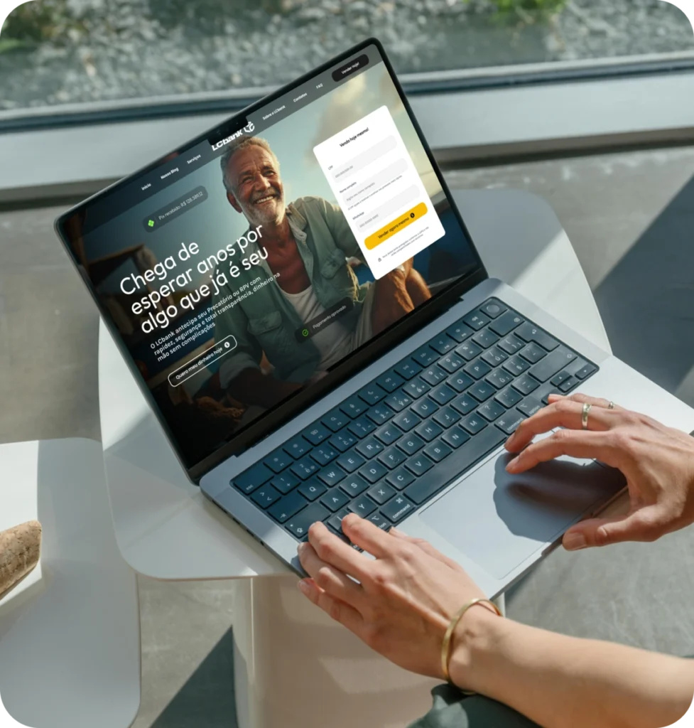 Laptop aberto exibindo site do LCbank com homem sorrindo.